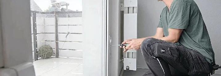 Person montiert Terrassentür mit Schraubendreher